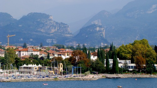 Riva del Garda und im Hintergrund auf einem Felsen die Burg von Arco